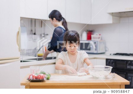 料理を手伝う女の子とお母さん 料理を手伝う女の子とお母さん 90958847