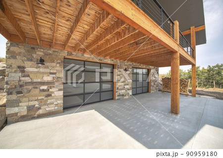 Custom home garage exterior with stone walls and double glass garage doors 90959180