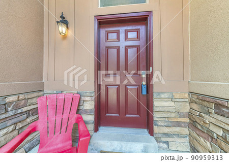 Burgundy door with blue lockbox and wall lamp on the left 90959313