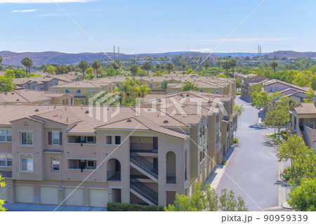 Apartment complex buildings with attached garage on the ground floor at Ladera Ranch, California 90959339
