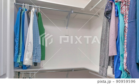 Panorama Walk in closet with an L-shaped wall mounted shelves with metal rods 90959596