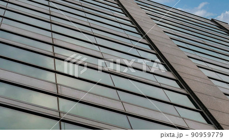 Panorama White puffy clouds Low angle view of a rise building facade with reflective glass w 90959779