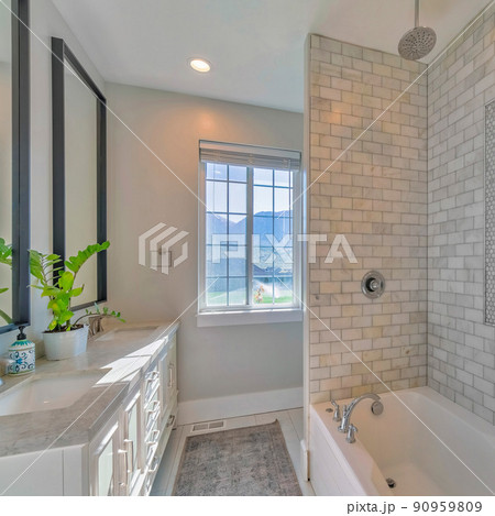 Square Luxurious bathroom interior with marble tiles and windows Square Luxurious bathroom interior with marble tiles and windows 90959809