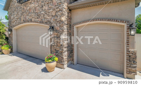 Panorama White puffy clouds Double arched sectional garage doors with potted plants outside Panorama White puffy clouds Double arched sectional garage doors with potted plants outside 90959810