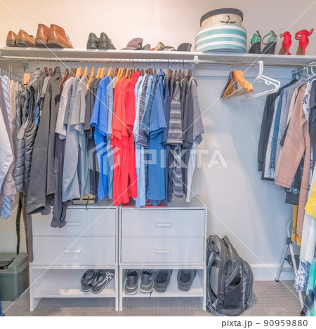 Square Interior of a windowless walk in closet with clothes and shoes 90959880