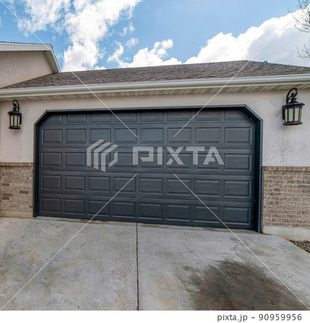 Square White puffy clouds Clipped corner black sectional garage door exterior with a concrete driveway 90959956