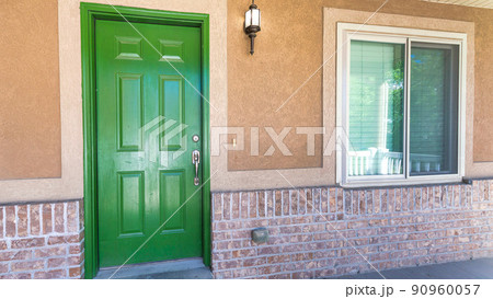 Panorama Front porch of a house with green wooden front door and wall lamp 90960057