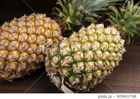 暗いテーブルの背景にカットしていないパイナップル 90963798