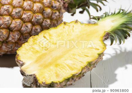 爽やかな白板の上に半分にカットしたパイナップル 90963800