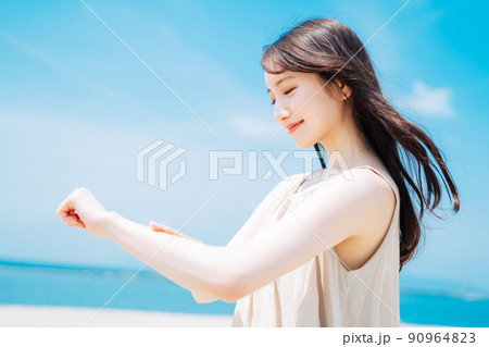 海で日焼け止めを塗る女性 海で日焼け止めを塗る女性 90964823