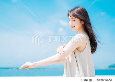 海で日焼け止めを塗る女性 90964828