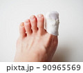 ガーゼ、包帯を巻かれた女性の足先。親指の怪我 90965569