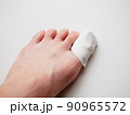 ガーゼ、包帯を巻かれた女性の足先。親指の怪我 90965572