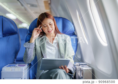 Travel, Portrait of an Asian business woman using tablet computer to plan while on a plane between waiting to negotiate business with foreign investors. 90968500