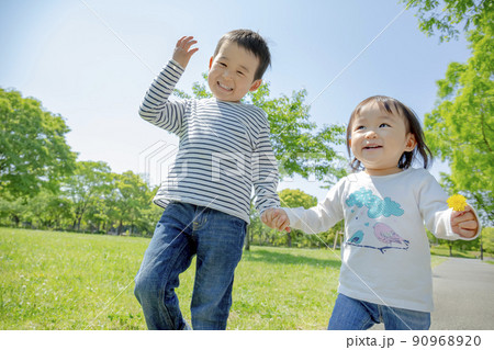 新緑の公園で遊ぶ兄と妹 90968920