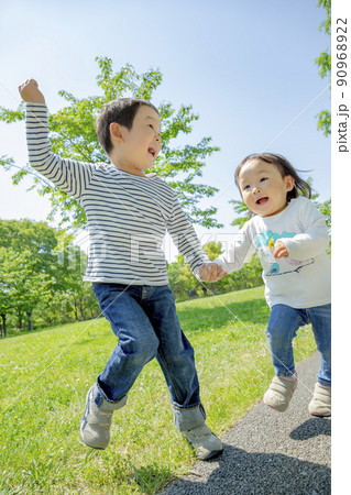 新緑の公園で遊ぶ兄と妹 新緑の公園で遊ぶ兄と妹 90968922