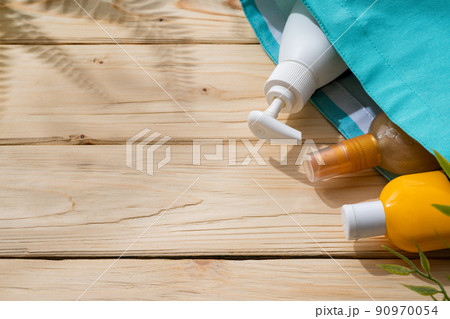Sunscreen cream bottles in beach bag on wooden background 90970054