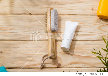 Foot brush and foot cream on wooden background Foot brush and foot cream on wooden background 90970119
