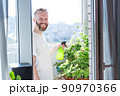 Man growing city balcony garden 90970366