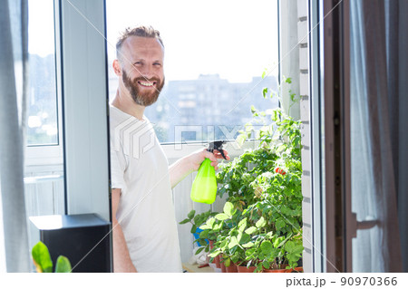 Man growing city balcony garden Man growing city balcony garden 90970366