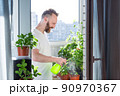 Man growing city balcony garden 90970367