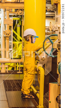 Boy operator recording operation of oil and gas process at oil and rig plant, offshore oil and gas industry, offshore oil and rig in the sea, operator monitor production process, routine daily record Boy operator recording operation of oil and gas process at oil and rig plant, offshore oil and gas industry, offshore oil and rig in the sea, operator monitor production process, routine daily record 90972281