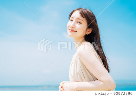 海と青空を背景にした女性 90972296
