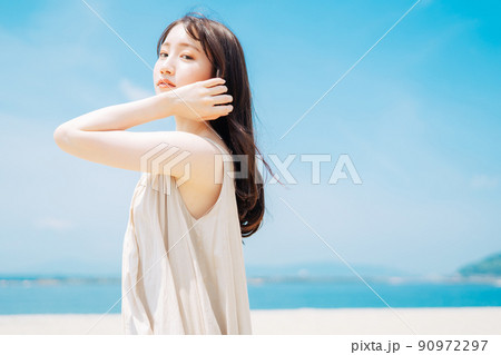 海と青空を背景にした女性 90972297