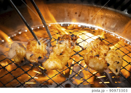 ロースターで炎に包まれた焼肉牛ホルモン【ミノ】 90973303