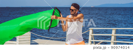 Man tries to inflate an air sofa. lamzac BANNER, LONG FORMAT Man tries to inflate an air sofa. lamzac BANNER, LONG FORMAT 90974014