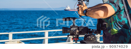 Professional steadicam operator uses a 3-axis camera stabilizer system on a commercial production set BANNER, LONG FORMAT Professional steadicam operator uses a 3-axis camera stabilizer system on a commercial production set BANNER, LONG FORMAT 90974029