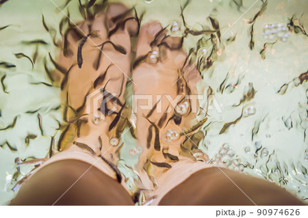 Young woman in a yellow dress at the fish spa 90974626