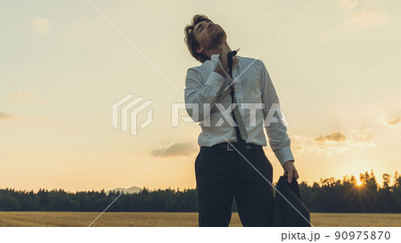 Exhausted businessman standing in nature Exhausted businessman standing in nature 90975870