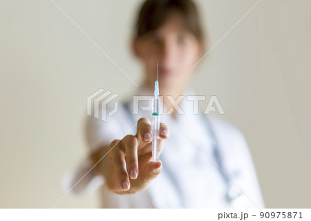 Nurse holding an injection needle Nurse holding an injection needle 90975871
