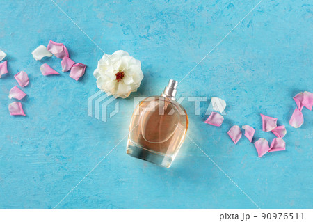 Rose fragrance bottle, a luxury product, shot from the top on blue Rose fragrance bottle, a luxury product, shot from the top on blue 90976511