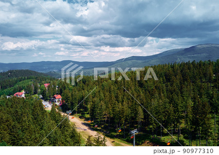 Aerial view of beautiful mountains, covered with forest and open cable car road. Karpacz resort in Poland with lift road. Family outdoor recreation in mountains 90977310