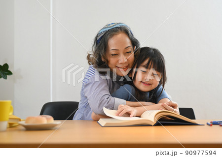 Caring grandma telling story, reading fairy tale to her little granddaughter. Multi generational, family and love concept 90977594
