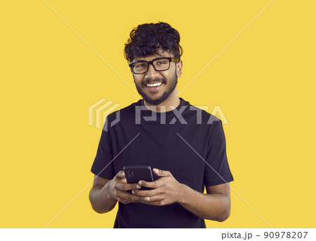 Smiling Indian man message online on cellphone 90978207