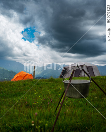 Camping in the mountains with tent standing on a hill, night and sunset landscape 90979822