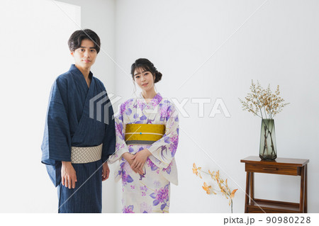 浴衣を着付けるカップル 90980228