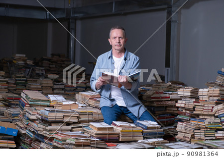 Portrait of Senior man with open book and looking at camera. Portrait of Senior man with open book and looking at camera. 90981364