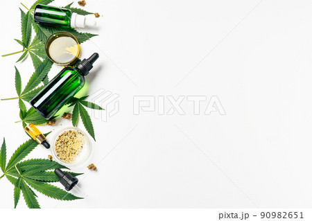 Cannabis oil, hemp leaves, dry flowers and peeled seeds in laboratory. Top view. Petri dishes and glassware on lab table. Dermatology concept, alternative treatment. Super food or natural cosmetics 90982651