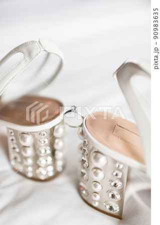 Wedding ring between wedding shoes and highlights Wedding ring between wedding shoes and highlights 90983635
