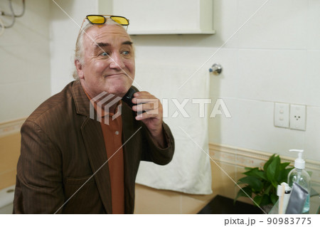 Elderly Man Shaving off Beard Elderly Man Shaving off Beard 90983775