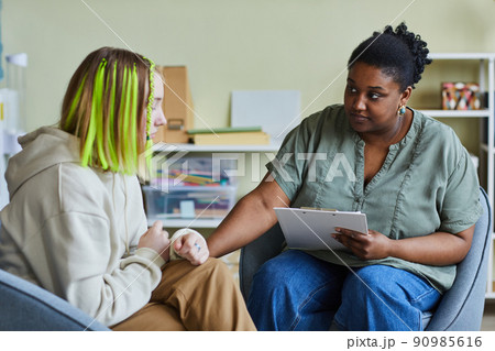 Psychologist working with upset girl at office 90985616