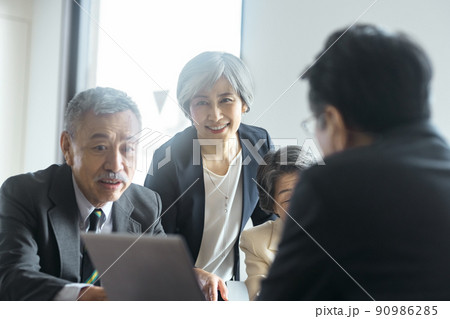 オフィスでミーティングするスーツ姿のシニアビジネスチーム 90986285