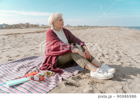 Calm pensive lady seated by the sea 90986986