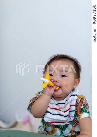 歯固めを嚙む7ヵ月の乳児　あかちゃん 90987199