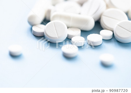 Various white pills on blue background against backlight. Various white pills on blue background against backlight. 90987720