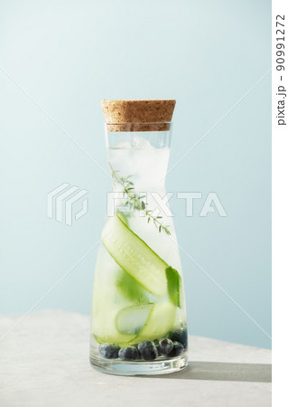 Summer drink with cucumber, blackberry and rosemary on blue sky background, healthy infused vitamin water Summer drink with cucumber, blackberry and rosemary on blue sky background, healthy infused vitamin water 90991272